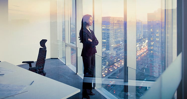 Business woman looking out of office windows